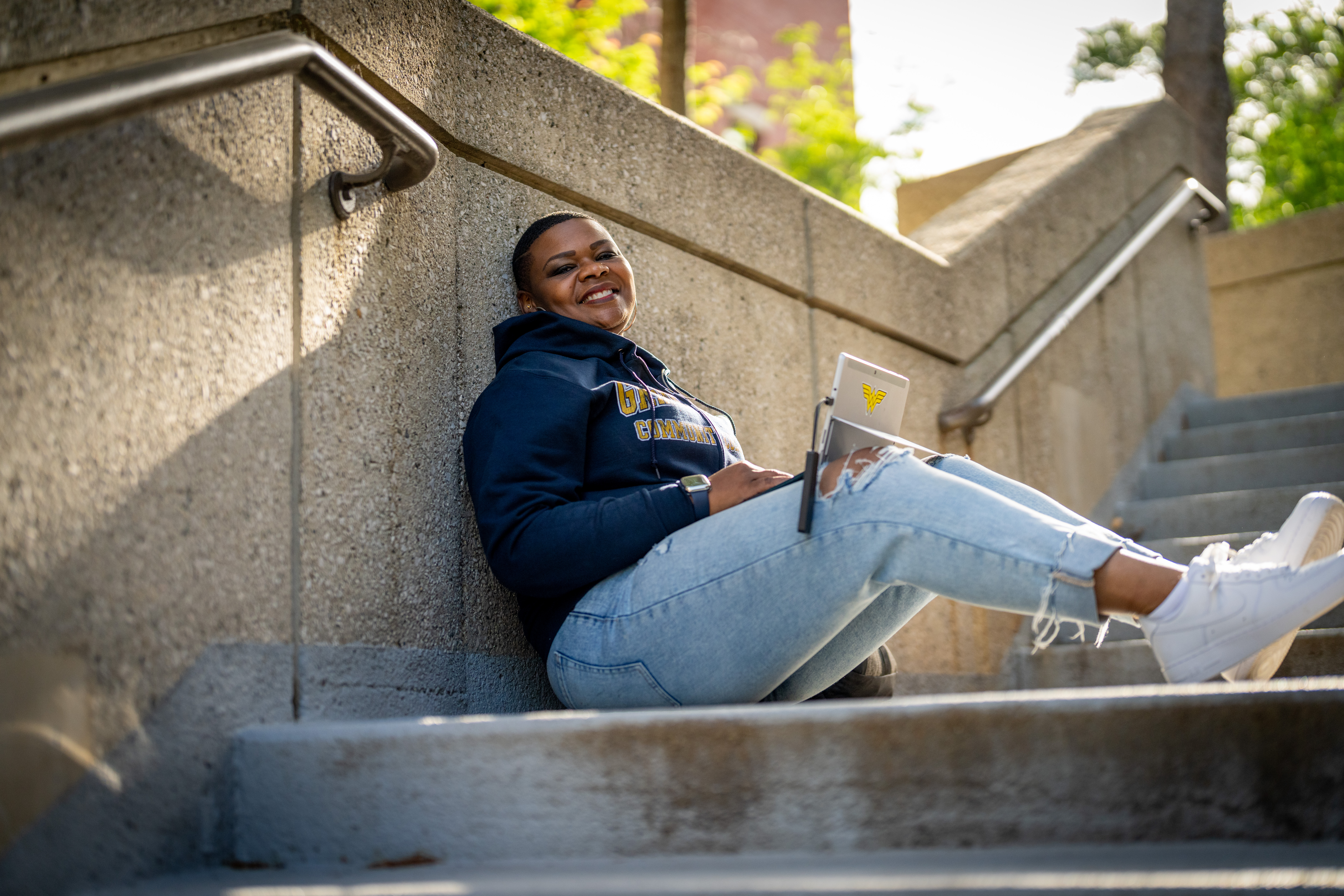Student sitting on the steps by the GRCC Library